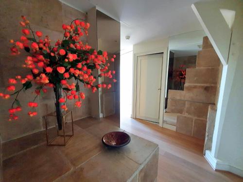a vase with red flowers in a room at La Côte Saint Jacques in Joigny