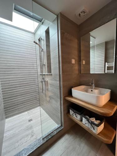 a bathroom with a sink and a glass shower at Nana's house in Chalkida