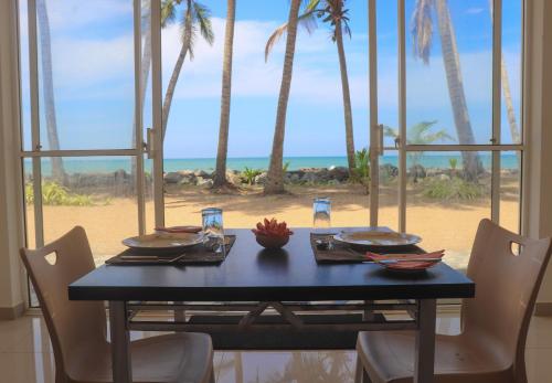 a dining room table with a view of the beach at OREO BEACH HOTEL KALUTARA in Kalutara