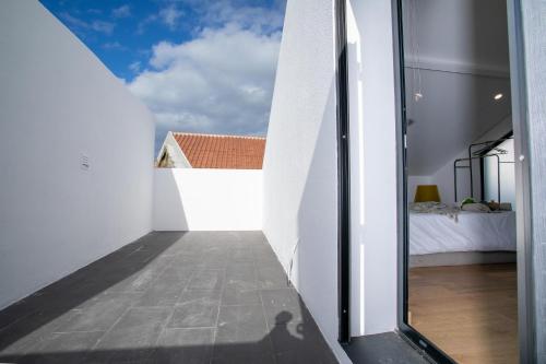 a view of a bedroom from the hallway of a house at Carvão Pdl Inn in Arrifes