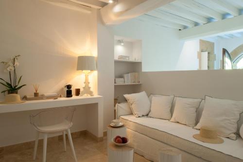 a living room with a white couch and a chair at Le Vieux Castillon in Castillon-du-Gard