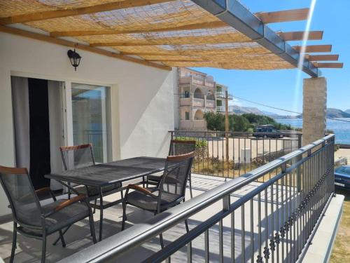 einen Tisch und Stühle auf einem Balkon mit Aussicht in der Unterkunft Sea View Apartment - first row to the beach in Zubovići