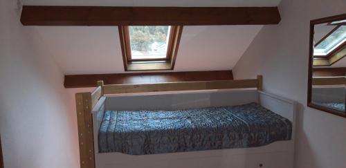 a small bed in a room with two windows at Montagne Ariégeoise in Aulus-les-Bains