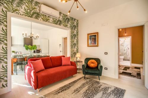 sala de estar con sofá rojo y silla en AwesHomeItaly - White Mirrors Apartment, en Pisa