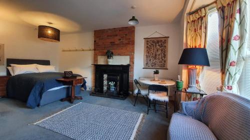 a bedroom with a bed and a desk and a fireplace at Stylish town centre apartments in Nailsworth