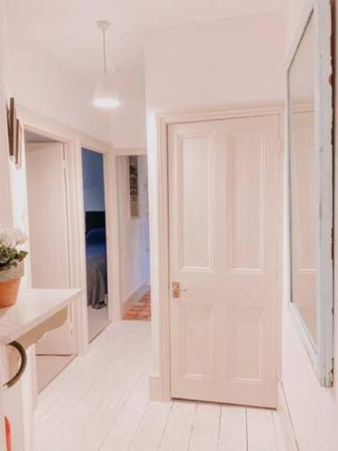 a white hallway with a white door in a room at Stylish town centre apartments in Nailsworth