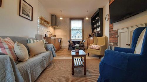 a living room with a couch and a table at Stylish Town Centre Apartments in Nailsworth