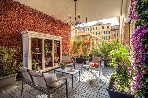 un patio con sillas y plantas en una pared de ladrillo en AwesHomeItaly - White Mirrors Apartment, en Pisa