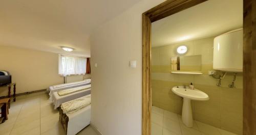 a bathroom with a sink and a bed and a mirror at Strand Motel, Vígadó Csárda in Dombrád