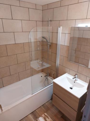 uma casa de banho com uma banheira, um lavatório e um chuveiro em Studio Le Flocon entièrement rénové em Les Orres