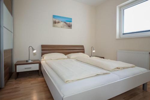 Giường trong phòng chung tại Haus-Ostseeapartments-am-Fehmarnsund-Wohnung-29-Ostseejuwel