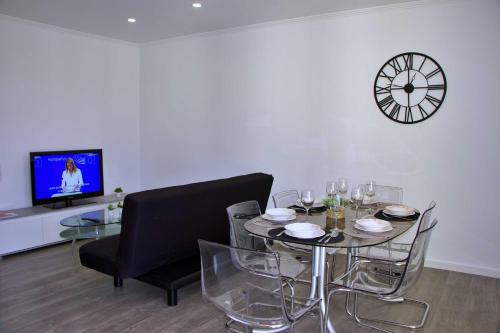 une salle à manger avec une table et une horloge murale dans l'établissement Apartamento DAVI, à Funchal