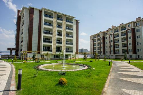 a park in front of a building with a fountain at Aforia Thermal Residences in Afyon