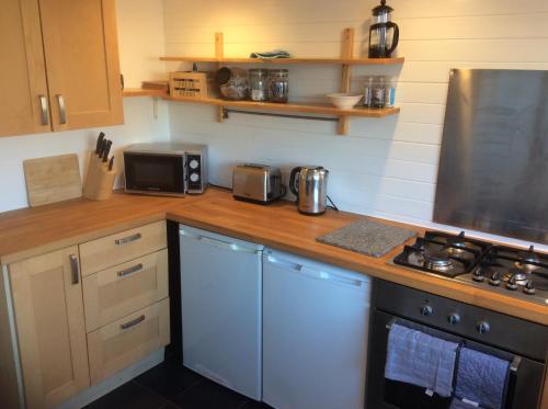 a kitchen with a counter with a stove top oven at Lovely Victorian town house close to the sea. in Bangor