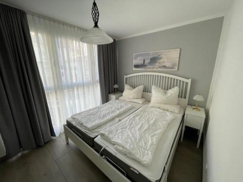 キュールングスボルンにあるPier Kühlungsbornのベッドルーム1室(白いシーツと枕のベッド1台付)