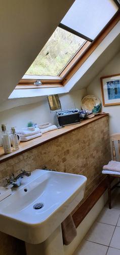 a bathroom with a sink and a window at Tracebridge Cottage B&B in Stawley