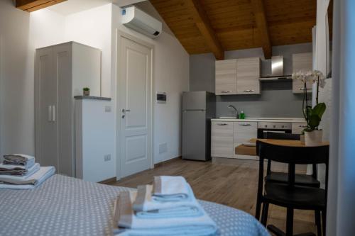 a room with a kitchen and a table with a table at Residence Le Palme in Torrazza Piemonte