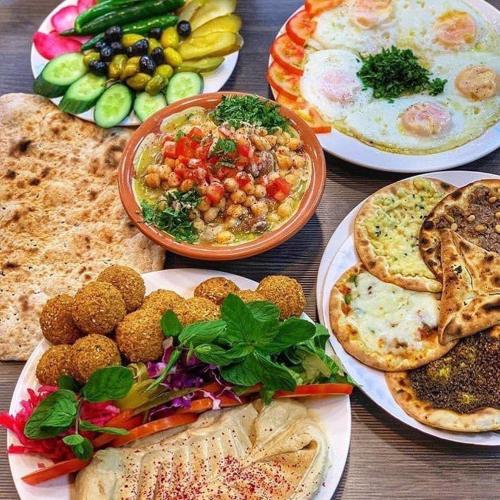 a table with many plates of food on it at P Quattro Relax Hotel in Wadi Musa