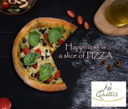 a slice of pizza on a table with happiness is a slice of pizza at P Quattro Relax Hotel in Wadi Musa
