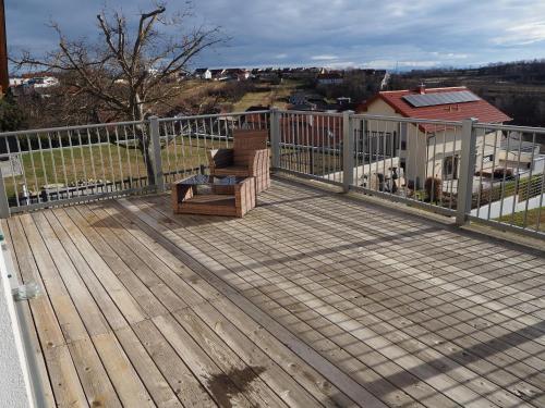 una terraza de madera con un banco sobre una valla en Asbacher Klosterkeller, en Stratzing