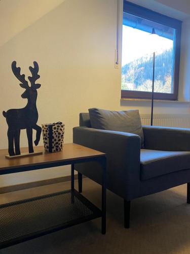 a living room with a couch and a table at Apartment am Park in Bad Lauterberg