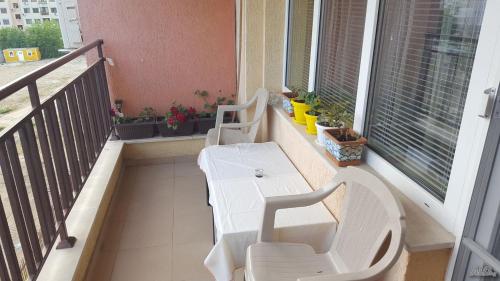 two white chairs and a table on a balcony at Апартамент Орхид Хилс in Varna City