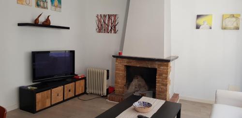 sala de estar con TV y chimenea en Casa cómoda y equipada para 6 en centro pueblo, en Torroella de Montgrí