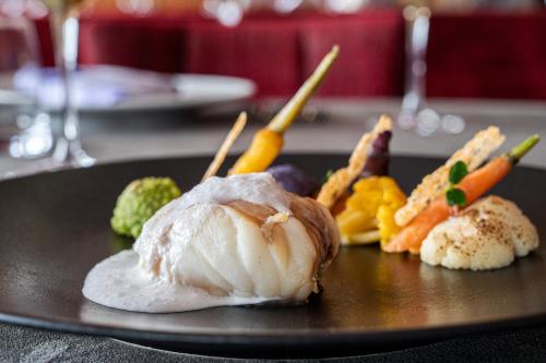 a plate of food with vegetables on a table at Hôtel les Campanules by Les Etincelles in Tignes