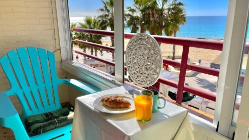 einen Tisch mit einem Teller Essen und Blick auf den Strand in der Unterkunft Liberty 4 personas Calpe centro in Calpe