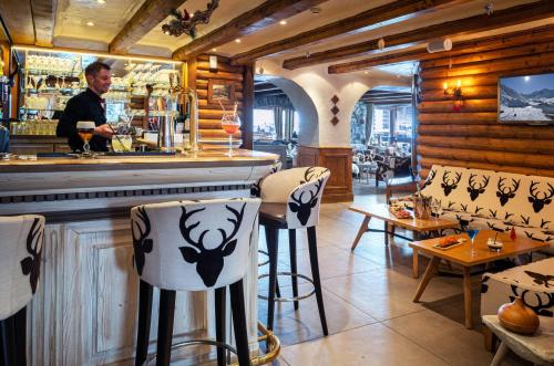 a man standing at a bar in a restaurant at Hôtel les Campanules by Les Etincelles in Tignes