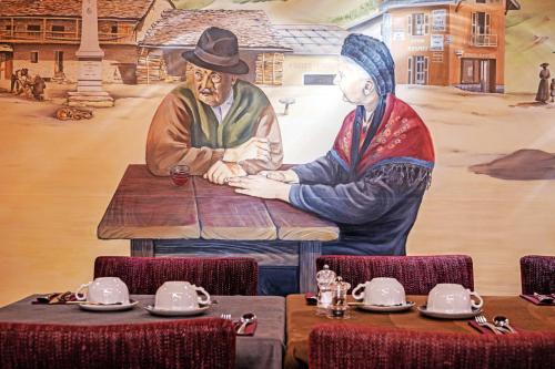 a mural of two men sitting at a table at Hôtel les Campanules by Les Etincelles in Tignes