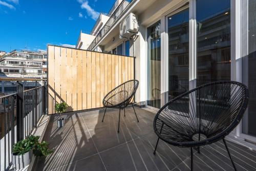 duas cadeiras sentadas na varanda de um edifício em Penthouse Apartments, The Luxury Suites em Tessalônica