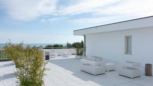 a white building with white benches on a patio at Residenza Excelsior in Vasto