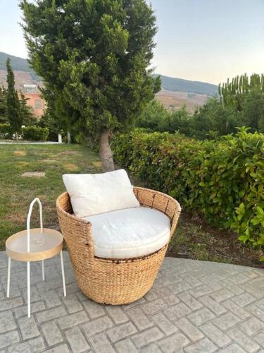 a wicker chair sitting on a patio with a table at Breathtaking view guesthouse2 in Psalidi