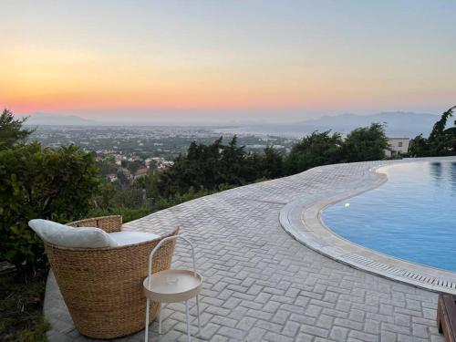 a swimming pool with a chair next to at Breathtaking view guesthouse2 in Psalidi
