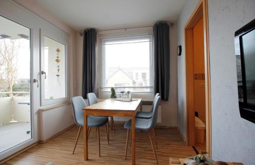 d'une salle à manger avec une table, des chaises et une fenêtre. dans l'établissement "Haus Wiking - Whg 14" - strandnah und ruhig gelegen, à Grömitz