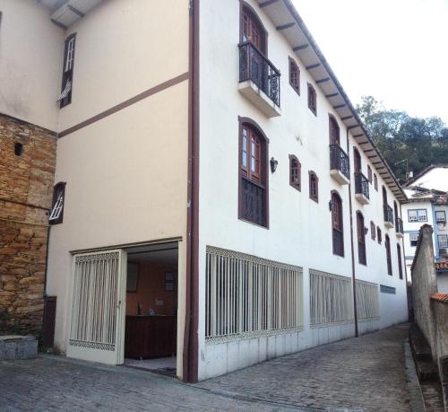 um grande edifício branco com garagem em Pousada Casa dos Contos em Ouro Preto