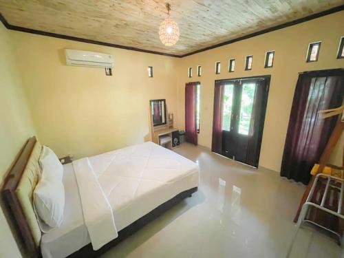 ein Schlafzimmer mit einem weißen Bett in einem Zimmer in der Unterkunft Ndalem Setumbu in Magelang