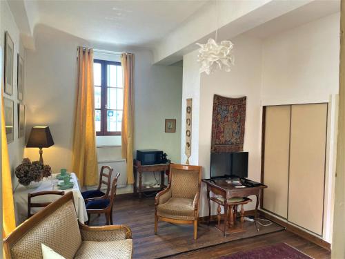 - un salon avec des chaises, une table et une télévision dans l'établissement Très bel appartement dijonnais place Wilson GUTEMBERT, à Dijon