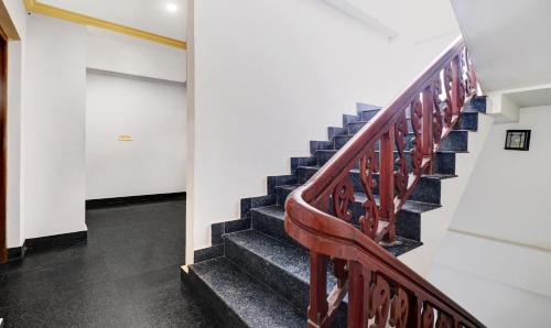 a staircase in a building with a wooden railing at Itsy Hotels The Waters Edge Beach Resort in Kovalam