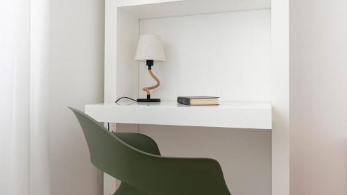 a white desk with a green chair and a lamp at Residenza Excelsior in Vasto