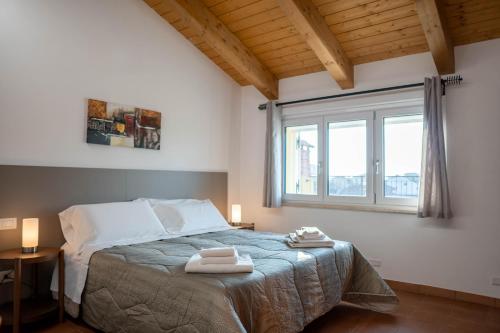 una camera da letto con un letto e due asciugamani di Residence Le Palme a Torrazza Piemonte