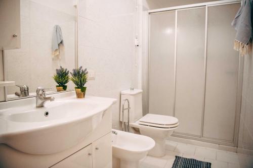 bagno bianco con lavandino e servizi igienici di Camping Wien a Peschiera del Garda