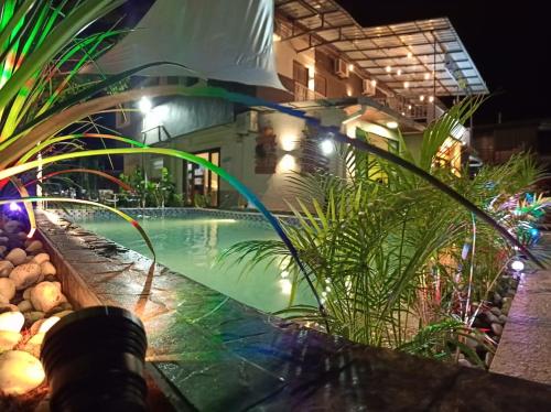 a swimming pool at night with plants and lights at Tc theme park Guest house in Kuantan
