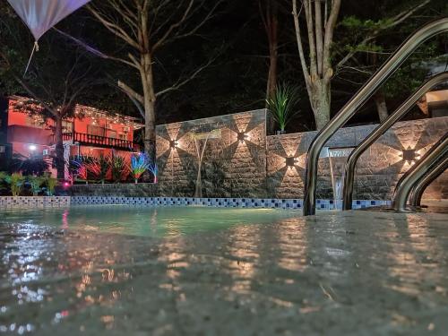 a swimming pool at night with lights at Tc theme park Guest house in Kuantan