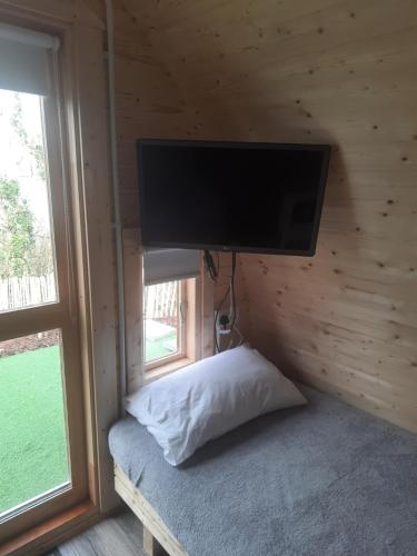 a bedroom with a flat screen tv on a wall at Ivy hill Glamping Pod in Ennis