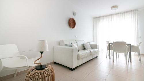a white living room with a white couch and a table at Residenza Excelsior in Vasto