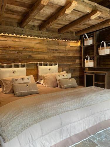 un grand lit dans une chambre aux murs en bois dans l'établissement Calme et sérénité - établissement classé, à Sixt-Fer-à-Cheval