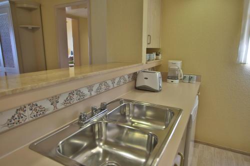 a kitchen with a sink and a counter top at The Royal Islander – An All Suites Resort in Cancún