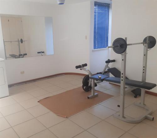 a room with a gym with a treadmill and a mirror at PENTHOUSE EN PLAYA EL AGUA in Los Cerritos
